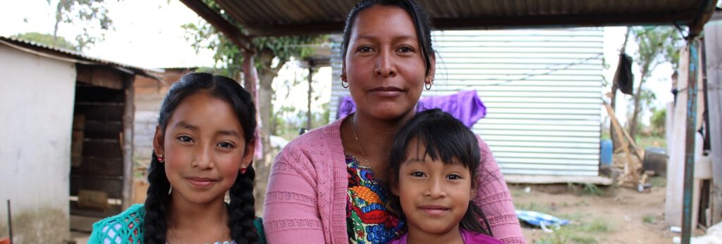 A woman and her two children sitting outdoors