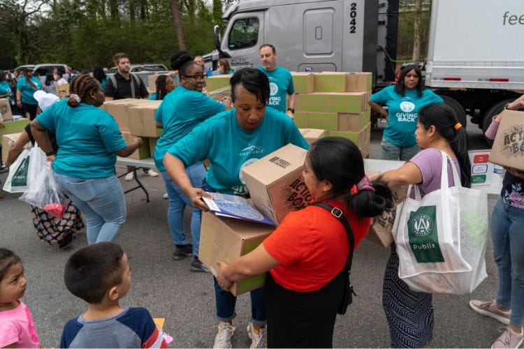 A group of people filling and carrying boxes at an event