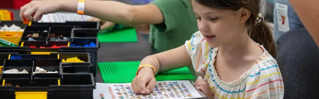 A girl sitting at a school table doing crafts