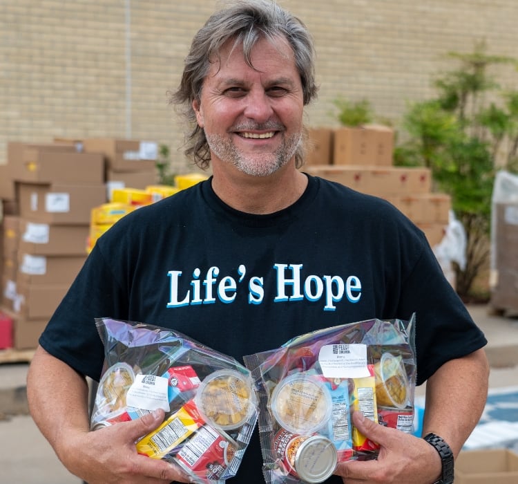 Life's hope volunteer holding food in bags