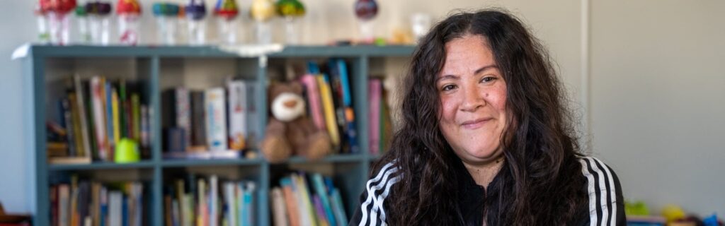 A woman smiling in front of a bookshelf