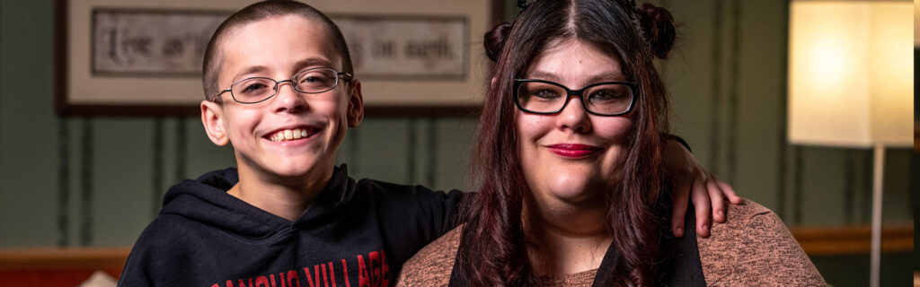 A mother and son smiling holding each other