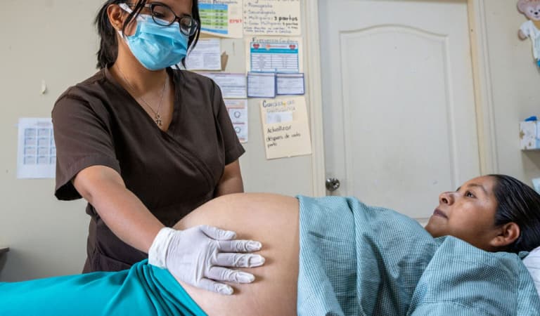 a woman getting an ultrasound in a hospital with a nurse