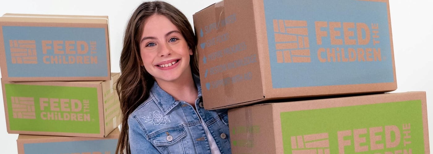 A girl holding feed the children boxes on a white background
