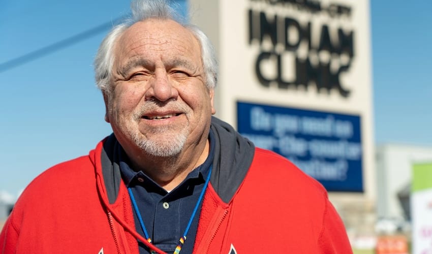 A man in a red coat standing outdoors at an event