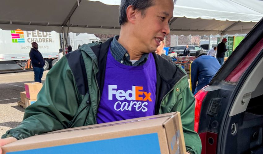 A man carrying a box of supplies at an event