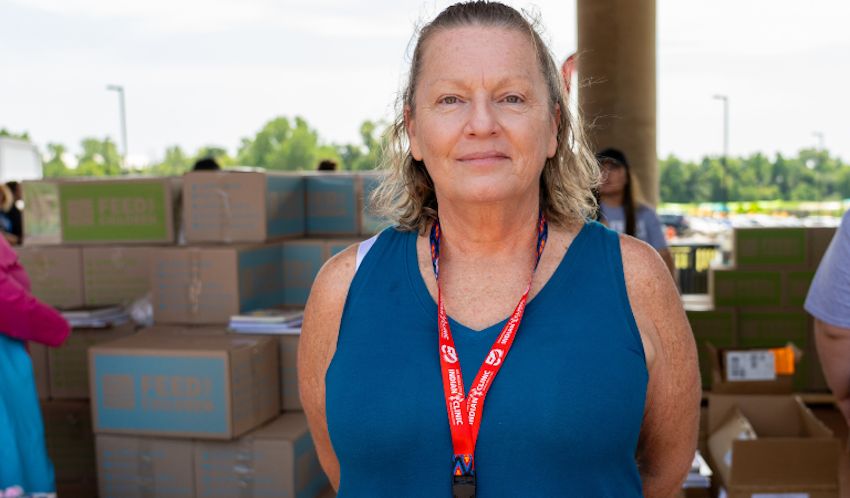 A woman standing in front of boxes at an outdoor event