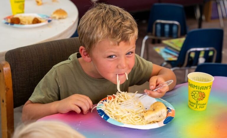 a boy eating food at a table