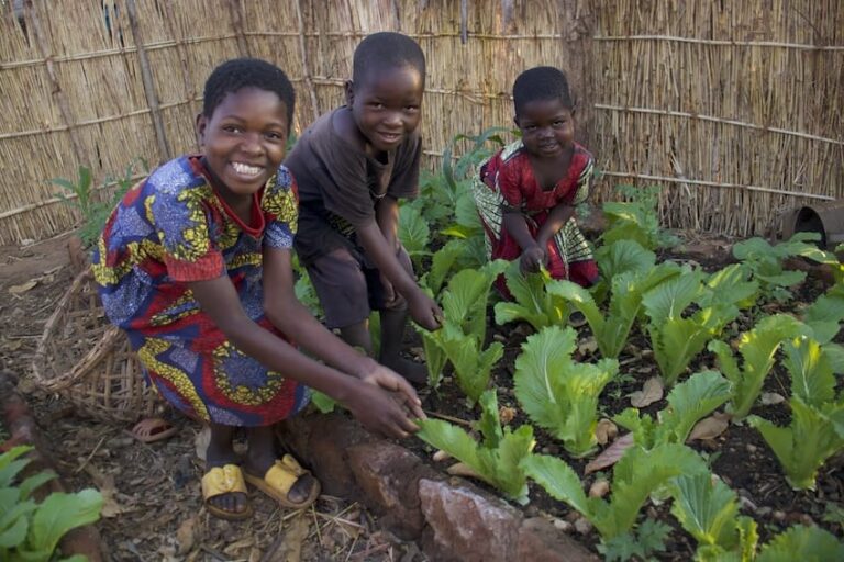 Three children working in a garden outdoors