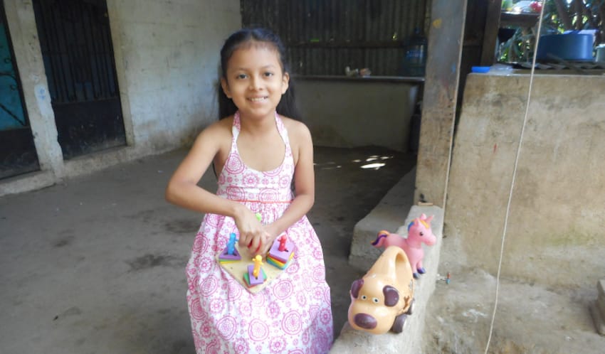 A child holding toys on a porch