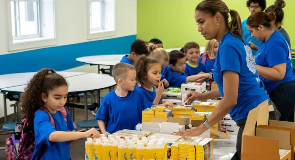 Volunteers handing out food supplies to children in line