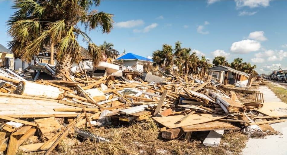 Broken homes and buildings laying on the ground as a result of a natural disaster