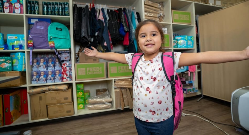 A child spreading arms standing in a resource room