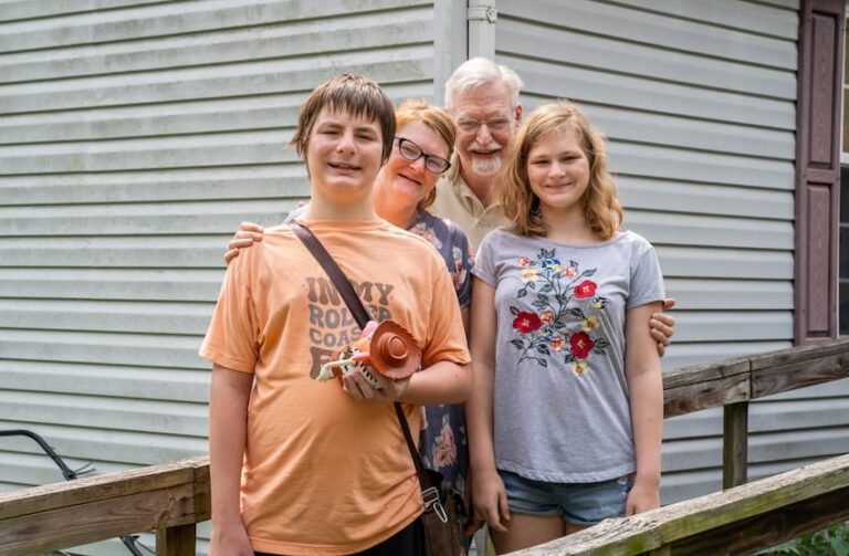 Mac and his family standing together outside a house