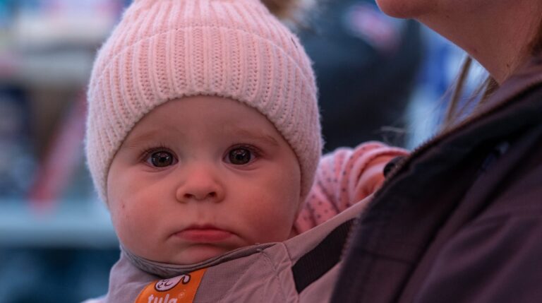 A baby being held by an adult.