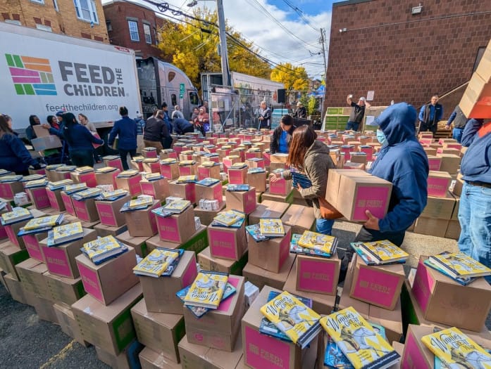 Volunteers distribute food, essentials and books to families at a Feed the Children No Hunger Holidays event.