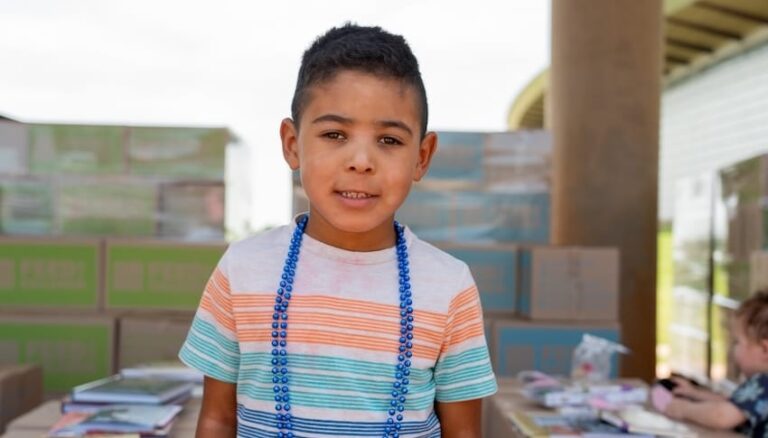 A boy standing in front of boxes at an outdoor event