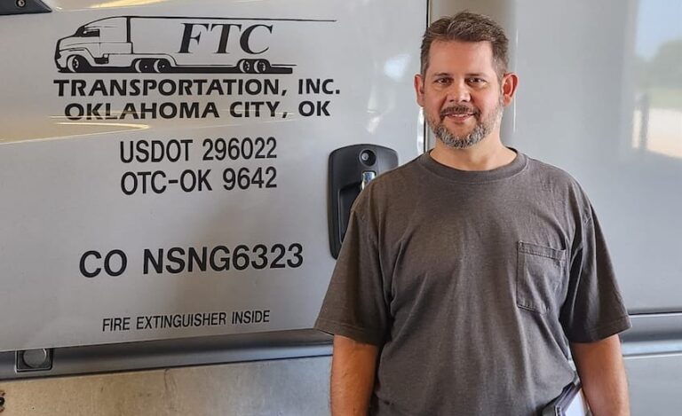 A man standing in front of a semi truck