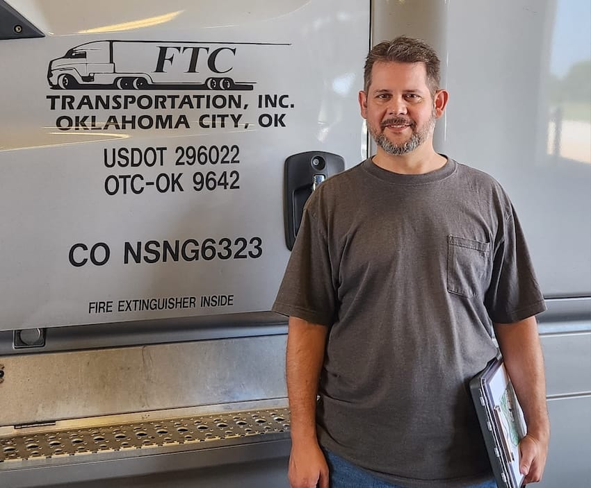 A man standing in front of a semi truck