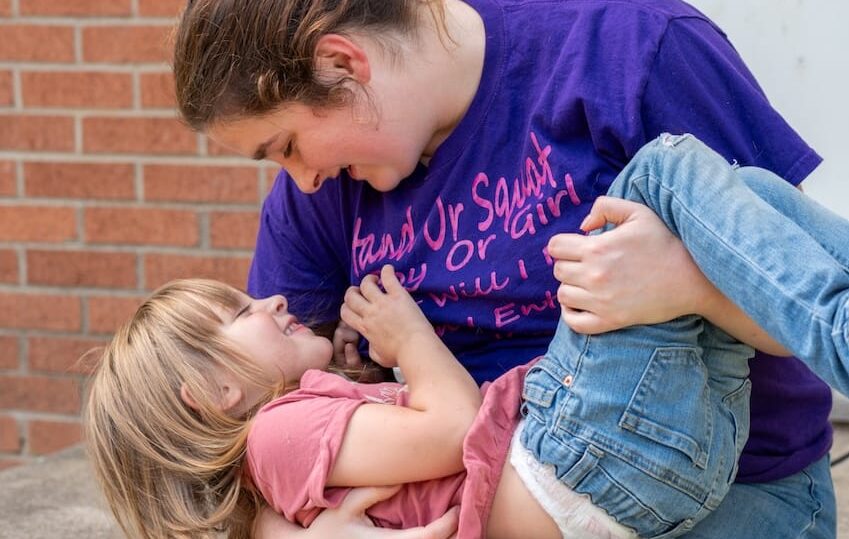 A mother and daughter playing together outdoors