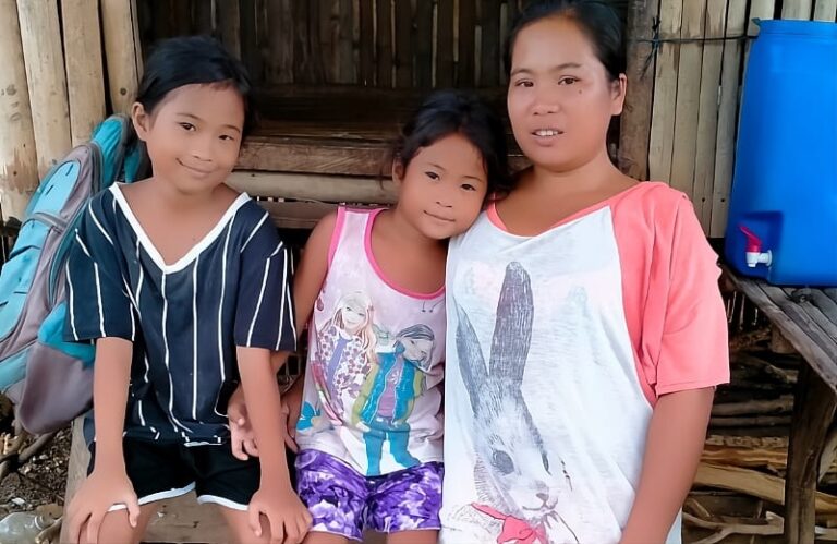 A mom and her two children outside a house