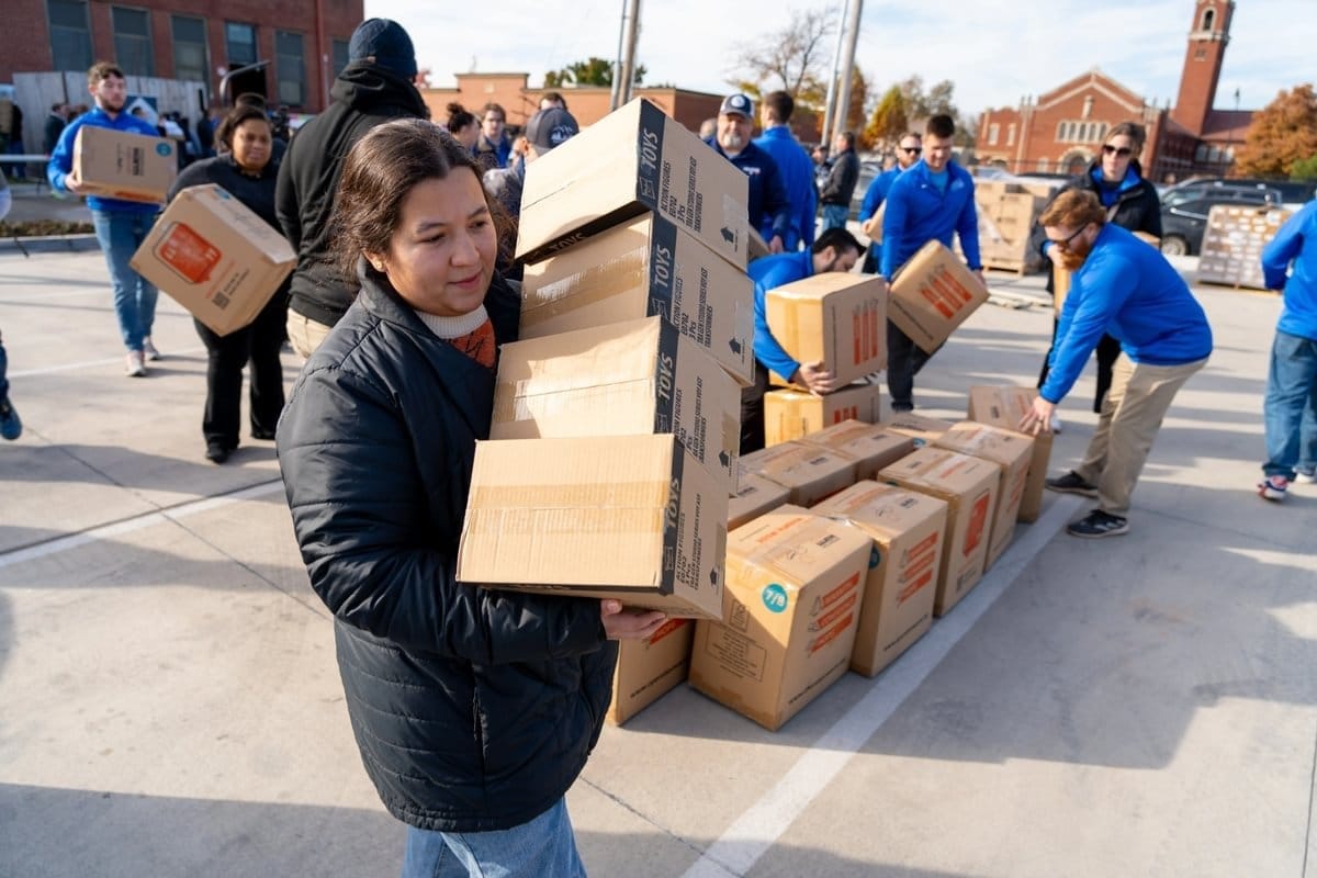 A woman handing out boxes at an event